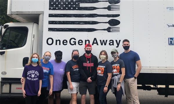 Volunteers stand in front of One Generation Away truck